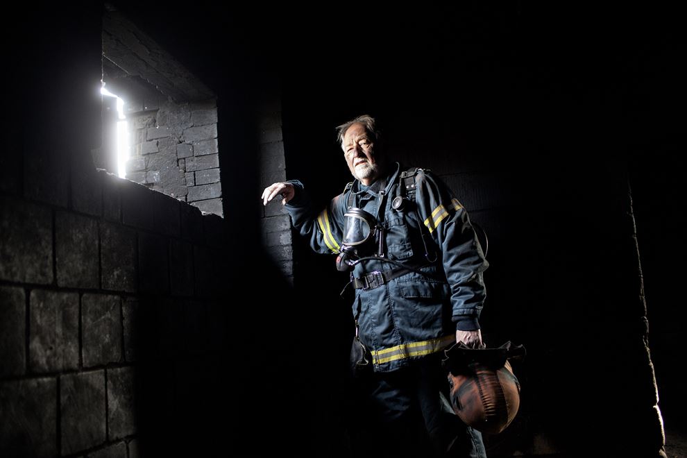 Brandmand står ved sodsværtet væg i nedbrændt hus
